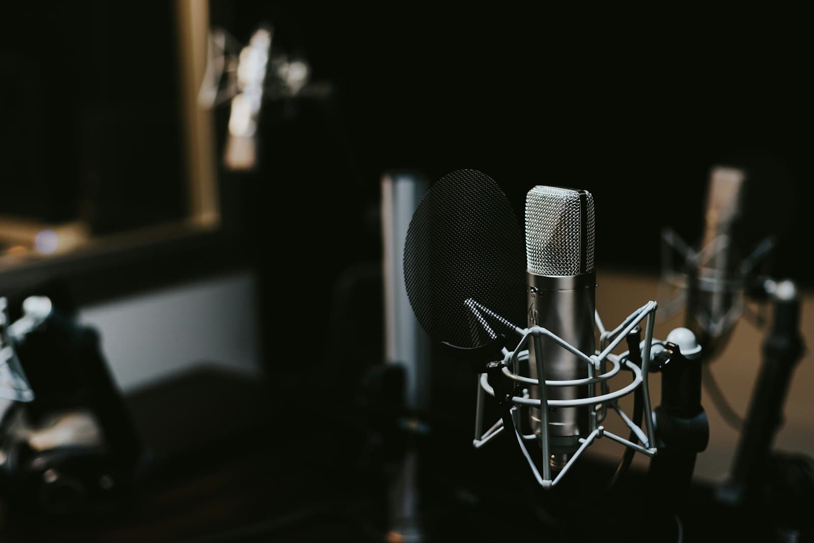 Condenser microphone in a dimly lit recording studio